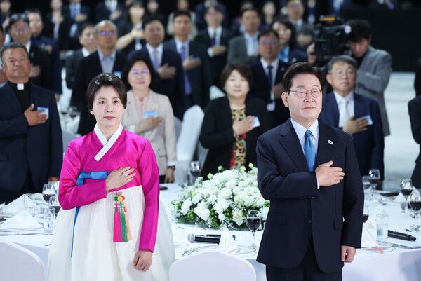 이재명&nbsp;대통령과 김혜경 여사가 10일(현지시간) 몽골 울란바타르 한 호텔에서 열린 동포 오찬간담회에서 국기에 경례를 하고 있다. [사진=연합뉴스]
