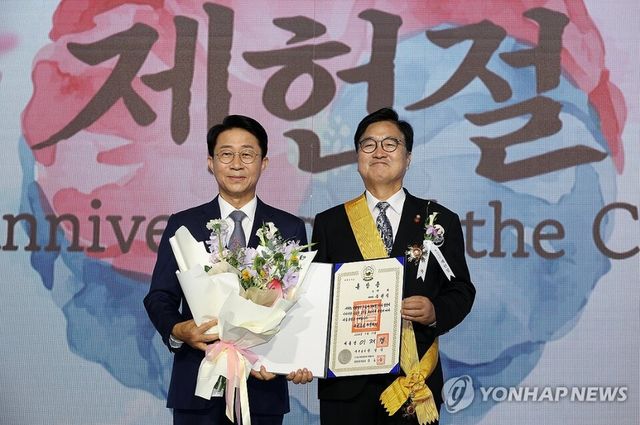 조정식 국회의장이 17일 서울 여의도 국회에서 열린 제78회 제헌절 경축식에서 우원식 전 국회의장에게 무궁화장을 전수하고 있다. 2026.7.17 [국회사진기자단=연합뉴스]