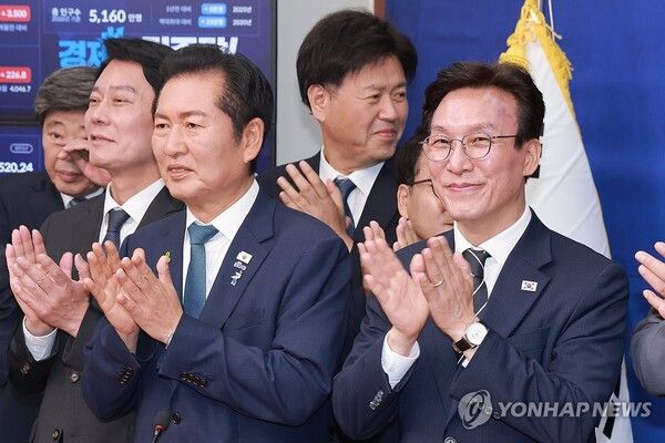 더불어민주당 정청래·김민석 당 대표 후보가 20일 국회에서 열린 민주당 공명선거 실천 서약식에 참석해 기념 촬영을 마치고 손뼉 치고 있다.[사진=연합뉴스]