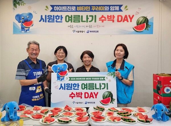 지난 22일 서울역 쪽방촌에서 2026 하이트진로 비타민 꾸러미와 함께 시원한 여름나기 '수박 DAY' 행사가 열렸다. (왼쪽부터) 쪽방촌 주민, 서울시 이신옥 팀장, 서울역 쪽방상담소 유호연 소장, 하이트진로 관계자가 기념 촬영을 하고 있다. [사진=하이트진로]