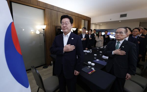 브라질을 국빈 방문 중인&nbsp;이재명&nbsp;대통령이 26일(현지시간) 브라질리아 한 호텔에서 열린 화상 수석보좌관회의에서 국기에 경례하고 있다. [사진=연합뉴스]