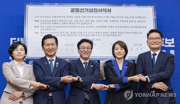 더불어민주당 8.17 전당대회에서 당 대표직에 출마하는 후보들이 20일 국회에서 열린 공명선거 실천 서약식에 참석해 문서에 서명한 뒤 손을 맞잡고 기념 촬영하고 있다. (왼쪽부터) 김보미, 정청래, 김민석, 고민정, 송영길 후보. [사진=연합뉴스]
