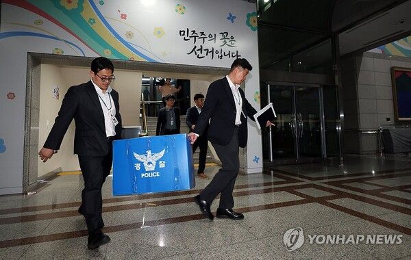 6·3 전국동시지방선거 투표용지 부족 사태를 들여다보고 있는 검경 합동수사본부 관계자들이 11일 과천시 중앙선거관리위원회에서 압수수색을 마친 뒤 압수품을 들고 건물을 나오고 있다. 2026.6.11 [공동취재]