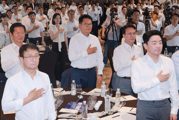 3일 서울 용산구 한 호텔에서 열린 더불어민주당&nbsp;국회의원 워크숍 참석자들이 국기에 경례하고 있다. 앞 테이블 왼쪽부터&nbsp;민주당&nbsp;정청래 전 대표, 한병도 대표 직무대행 겸 원내대표, 송영길 의원, 김민석 전 국무총리, 강훈식 대통령 비서실장. [사진=연합뉴스]