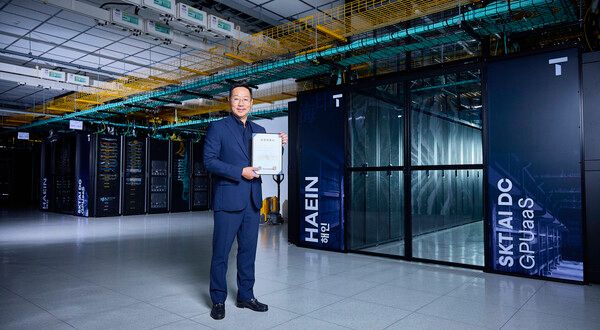 해인 클러스터 앞에서 김명국 SKT AI Factory 사업담당이 CSAP 인증서를 들고 포즈를 취하는 모습이다. [사진= SKT]