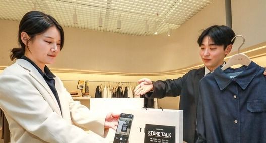 서울 강남구 현대백화점 무역센터점 7층에 위치한 타임 매장에서 고객이 스토어톡 QR코드를 스캔하고 있다. [사진=한섬]