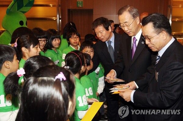 e파란의 아이들, 유엔 사무총장을 만나다: 2010년 11월 서울 삼성동 인터컨티넨탈호텔에서 'e파란 어린이 그린리더'들이 반기문 당시 유엔 사무총장(가운데)과 이승한 홈플러스그룹 회장(왼쪽)에게 환경사랑 다짐 편지를 전달하고 있다. 마트의 그림대회가 길러낸 아이들이 유엔 사무총장 앞에 서던, 홈플러스의 위상이 정점이던 시절이다. [사진=연합뉴스]​​​​​​​