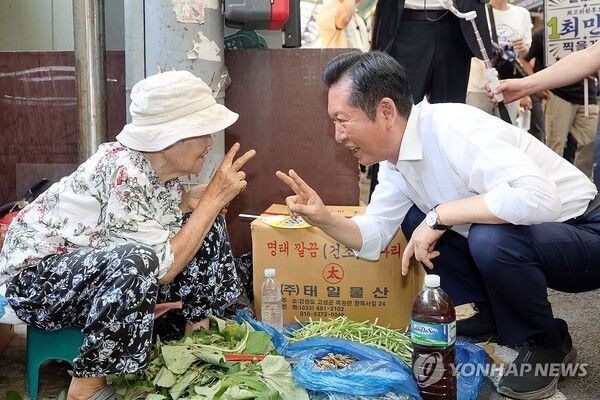 더불어민주당 정청래 당 대표 후보가 4일 오전 전남광주 북구 말바우시장에서 시장 상인에게 손가락으로 2번을 만들며 지지를 호소하고 있다. [사진=연합뉴스]