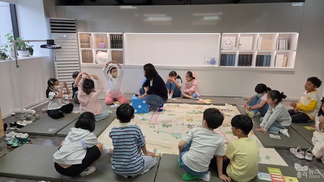 아이들이 대형 보드게임에서 화폐 퀴즈와 협동 미션을 수행하고 있다. [사진=권은주 기자]