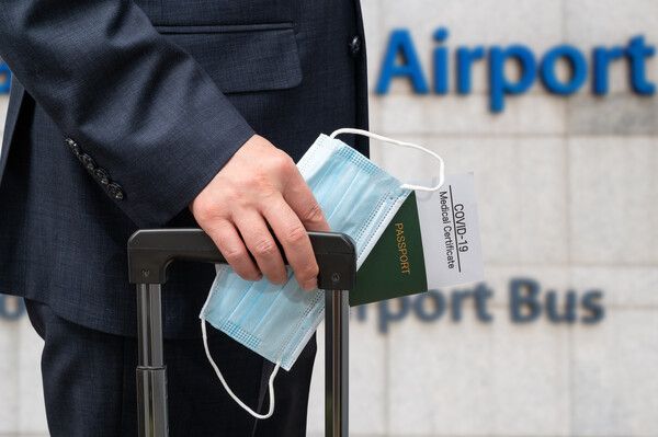 공항에서 한 고객이 마스크와 여권을 손에 쥐고 있는 모습. 사진=이미지투데이