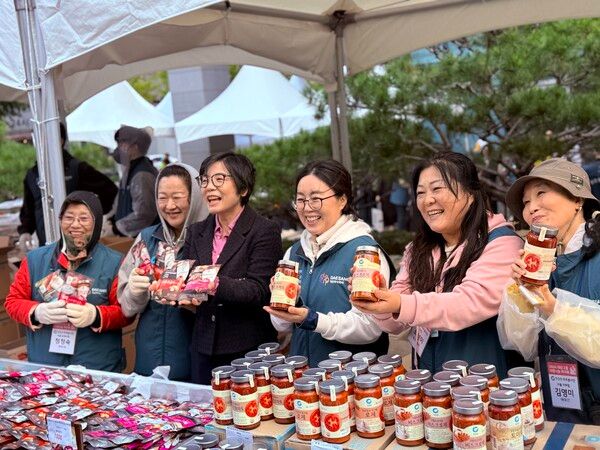 '2024 사랑나눔 바자회'가 진행 중인 가운데 양송희 푸드뱅크 단장과&nbsp;주부봉사단이 함께 파스타소스를 들고 미소를 짓고 있다. / 사진=신현수 기자.