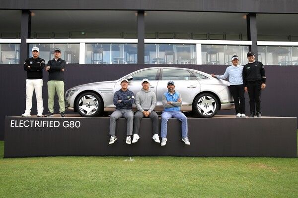 우승자 부상으로 제공되는 제네시스 G80 전동화 모델과 장유빈(왼쪽부터) , 귀도 밀리오치, 안병훈, 김주형, 파블로 라라사발, 박상현, 김민규 선수가 기념촬영을 하고 있다. /사진=제네시스