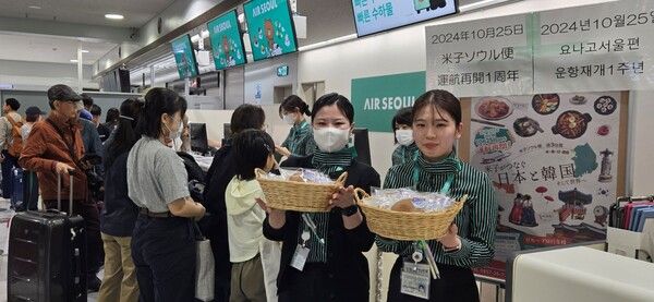 에어서울 직원이 요나고 운항 1주년을 축하하기 위해 요나고 공항에서 탑승객들에게 감사 선물을 나눠주고 있다. /사진=에어서울