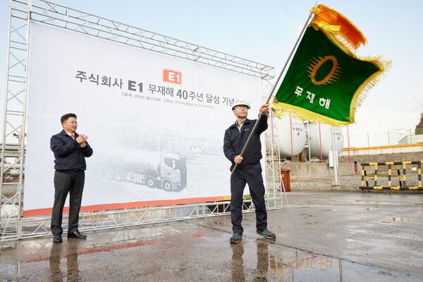 김욱주 E1여수기지장(오른쪽)이 올해 3월 여수기지에서 무재해 40년 달성 기념 깃발을 흔들고 있다. (제공=LS그룹)
