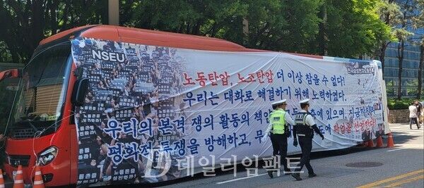 28일 오전 삼성전자 서초사옥 앞에 전국삼성전자노동조합이 설치한 버스 앞을 경찰이 지나가고 있다. /사진=황재희 기자