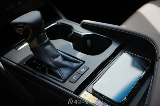 렉서스 ES300h의 기어 레버와 무선충전 패드. 기어 레버 하단에 차량 정지 시 브레이크를 떼도 출발하지 않게 막아주는 '오토 홀드'(왼쪽)와 배터리만 사용해 전기차와 같은 주행을 가능하게 하는 'EV 모드' 버튼이 자리해 있다. /사진=김현일 기자