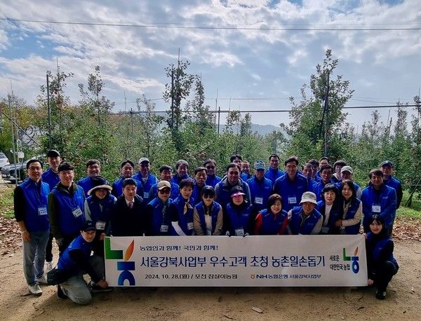 NH농협은행 강승구 서울강북사업본부장(사진 첫째줄 오른쪽에서 세번째)과 지점장 및 우수고객들이&nbsp;28일 포천시 창수면 소재 사과 농가를 방문해 사과수확 및 일대 자연 정화 활동 등 일손돕기에 구슬땀을 흘렸다. /사진=NH농협은행