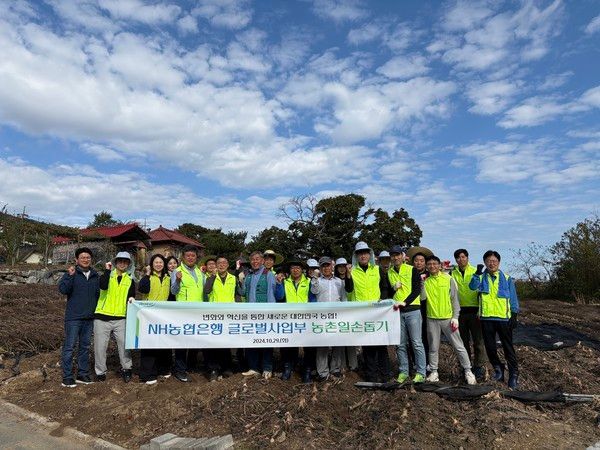 NH농협은행 글로벌사업부문 손원영 부행장(앞줄 왼쪽에서 다섯 번째)과 직원들이 남원주농협 직원들과 일손돕기를 실시하며 기념촬영을 하고 있다. /사진=NH농협은행