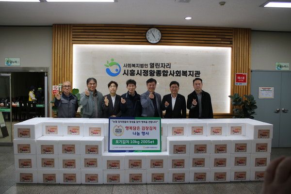 NH농협은행 황재현 IT부문 부행장(오른쪽에서 두 번째)과 서을구 IT노조위원장(왼쪽에서 세 번째)이 시흥시 관내 복지관을 찾아 김장김치 나눔 실시 후 기념 촬영을 하고 있다. /사진=NH농협은행