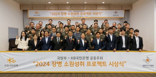 지난 7일 서울시 용산구에 위치한 국방컨벤션에서 열렸던 '2024 장병소원성취 프로젝트' 시상식에서 윤봉희 국방부 정책기획관(맨앞줄 좌측 5번째)과 서영익 KB국민은행 기관영업그룹대표(맨앞줄 좌측 6번째)가 수상자들과 함께 기념촬영을 하고 있다. /사진=KB국민은행