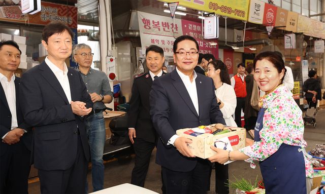 이호성 하나은행장(사진 왼쪽에서 다섯 번째)이 이찬진 금융감독원장(사진 왼쪽에서 두 번째)과 함께 전통시장에서 농산물을 직접 구입하고 기념 촬영을 하고 있다. / 사진=하나은행