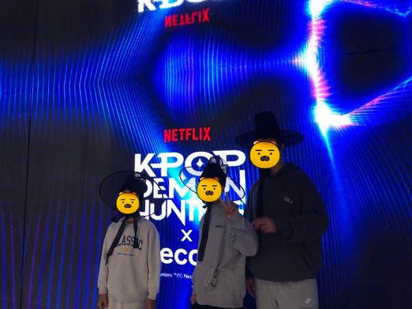 에잇세컨즈X케데헌 미디어월 앞에서 연출용 전통 갓을 쓰고 기념사진을 찍고 있는 방문객들 /사진=김현정 기자