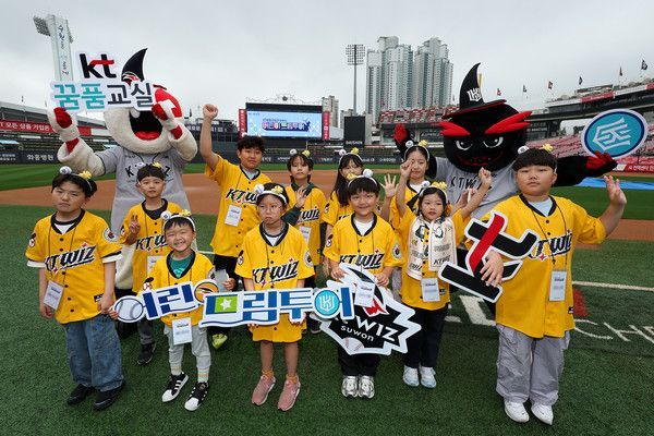 '어린이 드림투어'에 참여한 KT꿈품교실 아동들이 수원 KT위즈파크의 그라운드에서 기념 촬영을 하고 있다. /사진=KT