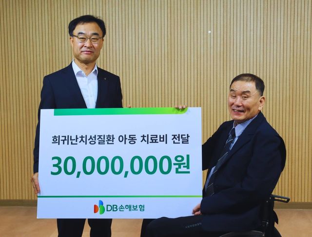 박성식 DB손해보험 부사장(왼쪽)과 김재학 한국희귀난치성질환 연합회 회장이 전달식을 갖고 기념촬영을 하고 있다. / 사진=DB손해보험