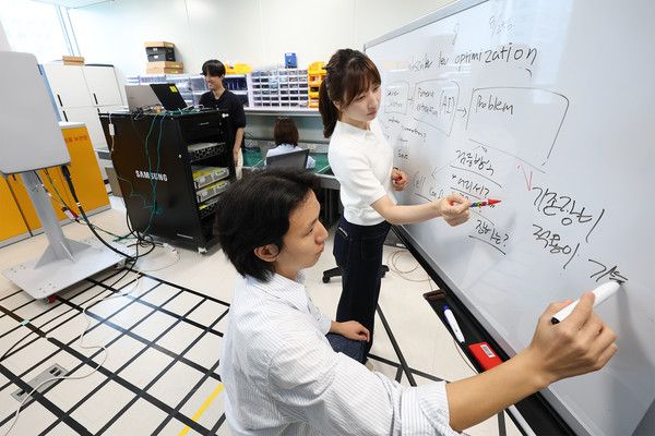 KT·삼성리서치 공동 연구팀이 무선망 최적화 기술 개발에 대한 논의를 진행하고 있다./사진=KT