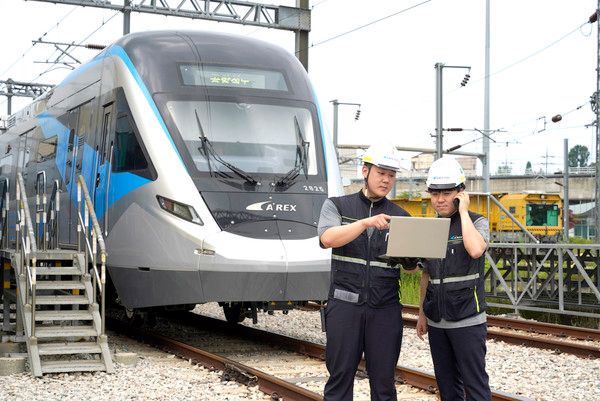 용유차량기지에서 공항철도 직원들이 5G 특화망에 연결된 노트북으로 객차·설비를 점검하고 있다./사진=LG유플러스