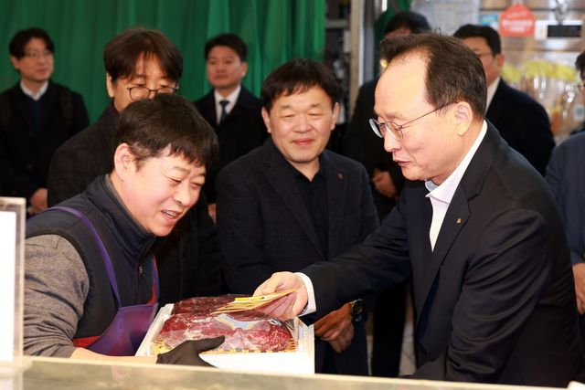 11일 망원시장에서 열린 '2026 설맞이 전통시장 사랑나눔' 행사에서 이환주 KB국민은행장이 식료품을 구입하고 있다. / 사진=KB국민은행