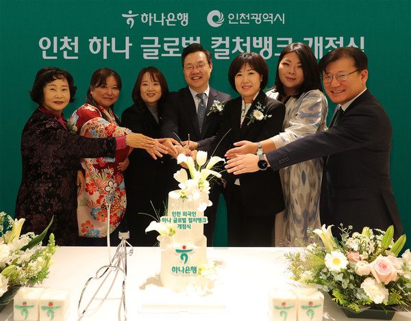 하나은행은 25일 인천 남동구 소재 남동산단금융센터지점 2층에 외국인 주민의 자립과 성장을 지원하기 위한 글로벌 커뮤니티센터 '인천 하나 글로벌 컬처뱅크'를 개점했다. 김미숙 하나은행 중앙영업그룹 부행장(사진 오른쪽에서 세번째), 하병필 인천광역시 부시장(사진 오른쪽에서 네번째) 및 행사에 참석한 관계자들이 축하 케이크를 자르며 기념 촬영을 하고 있다. / 사진=하나은행.