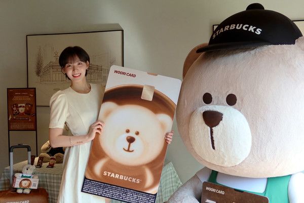 내달 14일까지 스타벅스 장충라운지R점에서 진행되는 '스타트래블 우리카드' 출시 기념 베어리스타 포토존에서 하지원 치어리더가 포즈를 취하고 있다. / 사진=우리카드