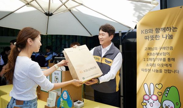 지난 13일 서울시 강남구 역삼동 KB손해보험 본사 로비에서 열린 '제21회 KB희망바자회'에서 KB손해보험 구본욱 사장(오른쪽)이 구매 고객에게 물건을 건네고 있다. / 사진=KB손해보험