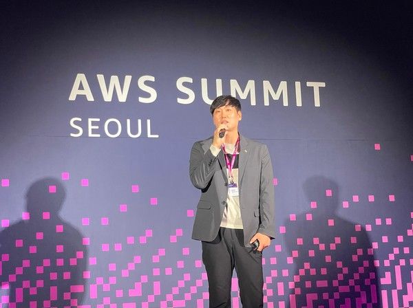 SM하이플러스 김성수 최고기술책임자(CTO)가 지난 20일 서울 강남구 코엑스에서 열린 ‘아마존웹서비스 서밋 서울 2026(AWS Summit Seoul 2026)’에서 연사로 무대에 올라 자사의 AWS 클라우드 전환 성과와 차세대 모빌리티 금융 플랫폼으로의 도약 비전에 대해 발표하고 있다. / 사진=SM그룹