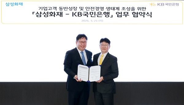 지난 21일 서울 여의도 KB국민은행 신관에서 열린 협약식에 참여한 권종우 삼성화재 일반보험부문 부사장(왼쪽)과 김현욱 KB국민은행 기업고객그룹 부행장(오른쪽)이 기념 촬영을 하고 있다. / 사진=KB국민은행