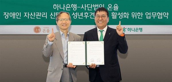 하나은행은 지난 15일 서울시 삼성동 소재 파르나스타워에서 사단법인 온율과 장애인 자산관리 신탁 및 성년후견 제도 활성화를 위한 업무협약을 체결했다. 이날 협약식에 참석한 윤세리 사단법인 온율 이사장(사진 왼쪽)과 김진우 하나은행 자산관리그룹 부행장이 기념 촬영을 하고 있다. / 사진=하나은행