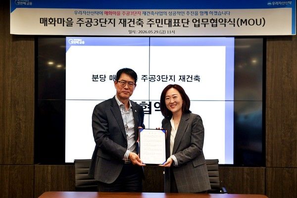 (왼쪽부터) 김범석 우리자산신탁 대표와 임은진 매화마을 주공3단지 주민대표단 위원장이 업무협약을 맺고 기념 촬영을 하고 있다. / 사진=우리자산신탁
