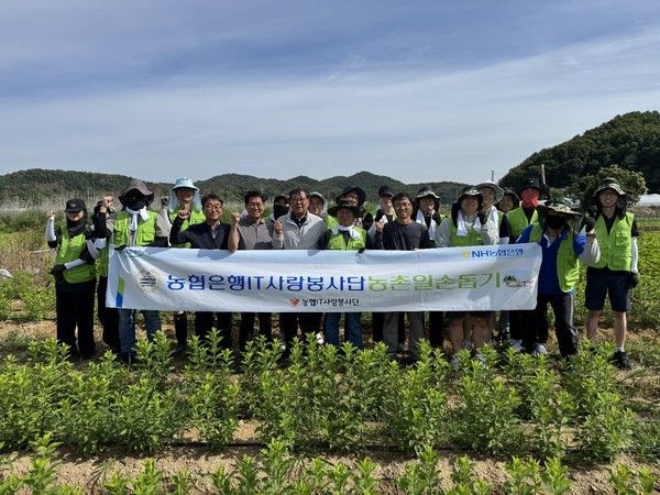 24일 강원도 춘천시 화훼 농가에서 NH농협은행 테크사업부문 임직원들이 잡초 제거 작업 전 기념 촬영을 하고 있다. / 사진=NH농협은행