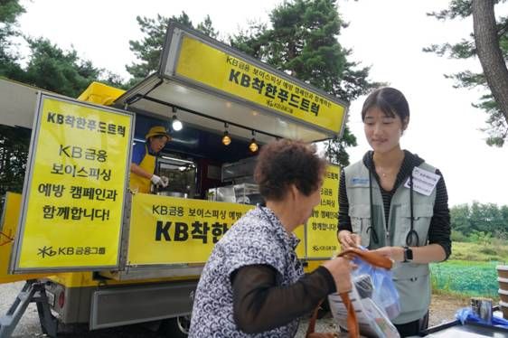 KB금융그룹 임직원들이 지난해 진행한 '찾아가는 보이스피싱 예방교육' 시즌1을 통해 농촌 지역 현장에서 보이스피싱 예방 교육자료를 제공하고 'KB착한푸드트럭'을 운영하고 있는 모습. / 사진=KB금융그룹