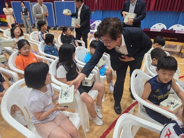 지난 20일 경북 영천시 단포초등학교에서 임도곤 NH농협금융지주 부사장이 학생에게 사회적기업이 생산한 수제쿠키를 전달하고 있다. / 사진=NH농협금융