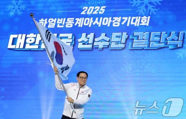 최홍훈 선수단장(대한스키스노보드협회 회장)이 24일 서울 송파구 올림픽파크텔 올림피아홀에서 열린 '2025 하얼빈 동계아시안게임' 대한민국 선수단 결단식에서 태극기를 흔들고 있다. 2025.1.24/뉴스1 ⓒ News1 김성진 기자