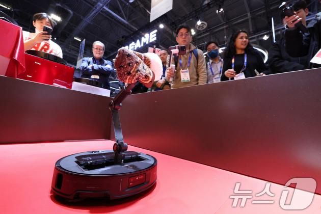 세계 최대 정보기술(IT)·가전 전시회 'CES 2025’ 둘째 날인 8일(현지시간) 미국 네바다주 라스베이거스 베네시안 엑스포에 마련된 로보락 전시관에서 로봇팔이 달린 로봇청소기가 양말을 치우고 있다. 2025.1.9/뉴스1 ⓒ News1 신웅수 기자