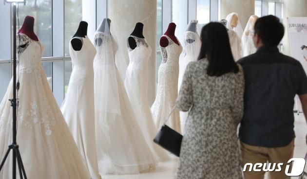 2019년 서울의 한 호텔에서 열린 웨딩 박람회를 찾은 예비 부부가 드레스 등 결혼 관련 상품을 둘러보고 있다. 2019.5.26/뉴스1 ⓒ News1 구윤성 기자