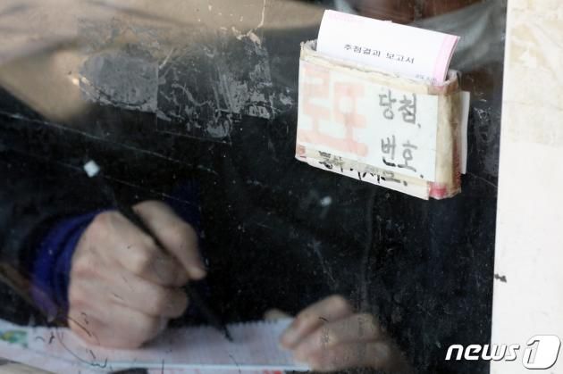 7일 오후 서울 동대문구의 복권판매점에서 한 시민이 로또 번호를 기입하고 있다. 2023.3.7/뉴스1 ⓒ News1 황기선 기자