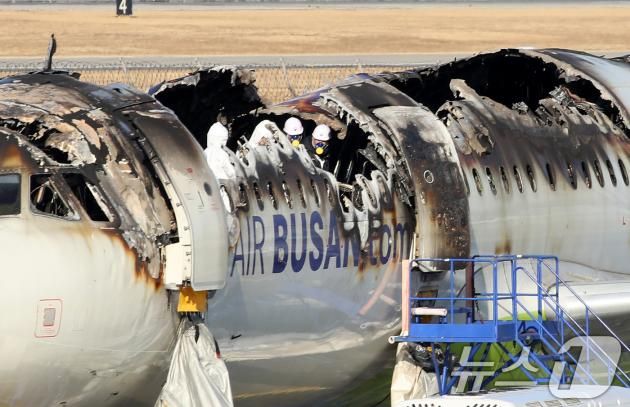 부산 강서구 김해국제공항에서 이륙을 준비하던 홍콩행 에어부산 항공기 BX391편 내부에서 불이 나 승객과 승무원 등이 비상 탈출한 가운데 29일 항공·철도사고 조사위원회(ARAIB) 등 관계자들이 불에 탄 항공기를 살펴보며 조사하고 있다. 28일 밤 항공기 화재 사고 당시 승객 170명(탑승 정비사 1명 포함)과 승무원 6명은 비상 슬라이드를 통해 전원 탈출했다. 2025.1.29/뉴스1 ⓒ News1 윤일지 기자