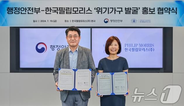 지난해 7월 구본근 행정안전부 스마트복지안전공동체추진단장(왼쪽)과 윤희경 한국필립모리스 대표이사가 서울 영등포구 한국필립모리스에서 위기가구 발굴·지원을 위한 업무협약을 체결한 모습. (행정안전부 제공)