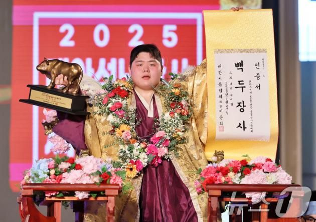 설날인 29일 충청남도 태안군 태안종합실내체육관에서 열린 ‘위더스제약 2025 태안설날장사씨름대회’에서 백두장사(140kg이하)에 등극한 김민재(영암군민속씨름단)가 장사인증서와 황소트로피를 들고 기념사진을 찍고 있다. (대한씨름협회 제공) 2025.1.29/뉴스1