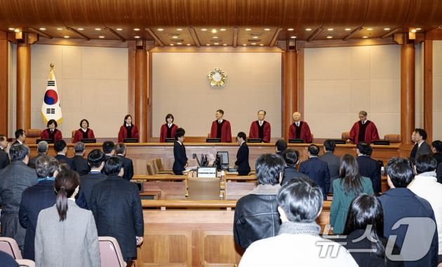 윤석열 대통령이 21일 오후 서울 종로구 헌법재판소 대심판정에서 열린 윤 대통령 탄핵심판 3차 변론기일에 출석했다. 이날 헌법재판관들이 입장하자 참석자들이 기립하고 있다. 2025.1.21/뉴스1 ⓒ News1 사진공동취재단