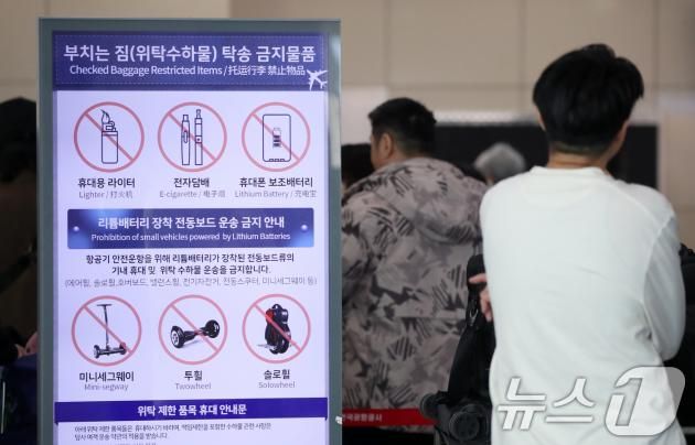 김해공항에서 발생한 에어부산 화재가 기내 선반에서 시작됐다는 목격자의 증언이 잇따르면서 휴대용 보조배터리가 화재 원인일 가능성이 제기되고 있는 가운데 30일 부산 강서구 김해국제공항 국제선 출국장에 설치된 부치는 짐(위탁수하물) 탁송 금지물품을 안내하는 전광판에 휴대폰 보조배터리 등이 표시돼 있다. 2025.1.30/뉴스1 ⓒ News1 윤일지 기자